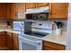 Close-up of a kitchen with modern white appliances, white countertop, and wooden cabinets at 1213 N Raven --, Mesa, AZ 85207