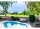 A backyard swimming pool with a grassy, green golf course beyond the backyard walls at 1213 N Raven --, Mesa, AZ 85207