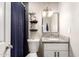 Bathroom featuring granite vanity, an accent wall, decorative shelves, and a shower with a blue curtain at 1257 N 47Th Pl, Phoenix, AZ 85008