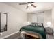 Cozy bedroom featuring a ceiling fan, area rug, and a comfortable-looking queen-size bed with decorative pillows at 1257 N 47Th Pl, Phoenix, AZ 85008