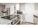 Well-lit kitchen with white cabinets, modern appliances, and granite countertops at 1257 N 47Th Pl, Phoenix, AZ 85008