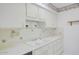 Well-lit kitchen featuring ample countertop space and white cabinetry at 12887 N 99Th Dr, Sun City, AZ 85351