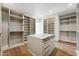 Spacious walk-in closet with custom shelving and center island with drawers at 13116 E Desert Holly Dr, Scottsdale, AZ 85255