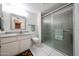 Bathroom featuring a glass-enclosed shower, granite vanity, and bright white tiled flooring at 13251 W Aleppo Dr, Sun City West, AZ 85375