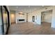 Open-concept living room featuring wood floors, a modern fireplace, and large windows for natural light at 13302 E Buckskin Trl, Scottsdale, AZ 85255