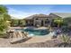 Gorgeous backyard with sparkling pool, rock features, lush landscaping, and comfortable seating area, perfect for outdoor entertaining at 14442 N Prickly Pear Ct, Fountain Hills, AZ 85268