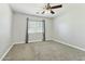 Carpeted bedroom with neutral walls, a ceiling fan, and large window with curtains at 14970 N 172Nd Dr, Surprise, AZ 85388