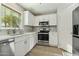 Bright kitchen with white cabinets, stainless steel appliances, tile backsplash and wood look tile floors at 14970 N 172Nd Dr, Surprise, AZ 85388