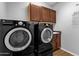 Well-equipped laundry room with dark washer and dryer, plus cabinet storage at 16210 E Links Dr, Fountain Hills, AZ 85268