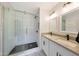 Bathroom featuring a tiled walk-in shower, dual sink vanity with modern fixtures and decorative floor tiles at 1709 W Clarendon Ave, Phoenix, AZ 85015