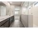 Bright bathroom featuring dual sinks, a glass shower, and views into the bedroom at 17843 W Encinas Ln, Goodyear, AZ 85338