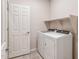 Bright laundry room features modern appliances, tiled floor, a shelf and white door at 17843 W Encinas Ln, Goodyear, AZ 85338