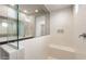 Modern shower with white tile, glass enclosure, built-in bench, and convenient storage niche at 17843 W Encinas Ln, Goodyear, AZ 85338