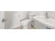 Half bathroom featuring white toilet and pedestal sink, complemented by neutral tile flooring at 18166 E Colt Dr, Queen Creek, AZ 85142