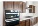 Close-up of modern appliances: double oven, gas cooktop, stainless hood and white backsplash at 18166 E Colt Dr, Queen Creek, AZ 85142