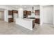 Bright kitchen with an oversized white island, stainless hood, cooktop, and dark wood cabinetry at 18166 E Colt Dr, Queen Creek, AZ 85142