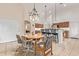 Charming dining area with chandelier, wood table, and bar seating in the background at 18415 W Port Au Prince Ln, Surprise, AZ 85388