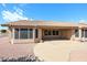 Exterior view of the back of a house featuring a covered patio and gravel landscaping, creating a low-maintenance outdoor space at 19507 N 90Th Ln, Peoria, AZ 85382