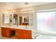 Bathroom featuring double sinks, a large mirror and a soaking tub at 19507 N 90Th Ln, Peoria, AZ 85382