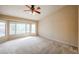 Spacious bedroom featuring a ceiling fan and bright natural light at 19507 N 90Th Ln, Peoria, AZ 85382