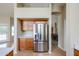 A stainless steel refrigerator and wooden cabinets connect the kitchen to the dining area at 19507 N 90Th Ln, Peoria, AZ 85382