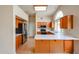 Modern kitchen featuring wood cabinets, a breakfast bar, white countertops, and stainless steel appliances at 19507 N 90Th Ln, Peoria, AZ 85382