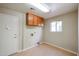 Neutral laundry room featuring functional wooden cabinets and a light hardwood floor for a clean and organized space at 19507 N 90Th Ln, Peoria, AZ 85382