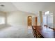 Bright living room with beige walls, carpet flooring, and a wooden dining table at 19507 N 90Th Ln, Peoria, AZ 85382