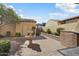 Charming backyard featuring a brick patio, lush greenery, and a tiered fountain at 21141 W Main St, Buckeye, AZ 85396