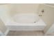 White bathtub with chrome fixtures in bright, neutral-toned bathroom at 21141 W Main St, Buckeye, AZ 85396