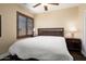 Bedroom with ceiling fan, shuttered window, and neutral wall paint at 21141 W Main St, Buckeye, AZ 85396