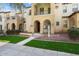 Inviting two-story townhome showcases beautiful architecture and a well-maintained green lawn at 21141 W Main St, Buckeye, AZ 85396