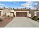 Home exterior with a large brown garage door and well-maintained landscaping at 21141 W Main St, Buckeye, AZ 85396