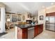 Open kitchen view with stainless appliances, granite counters, and sightlines to the living area and fireplace at 21141 W Main St, Buckeye, AZ 85396