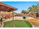 Outdoor living space features a covered patio, built-in grill, outdoor seating, a pool and a putting green at 22412 N 20Th Pl, Phoenix, AZ 85024