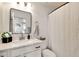 Simple bathroom with a large mirror, white vanity, and a shower with white curtain at 22412 N 20Th Pl, Phoenix, AZ 85024