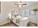 Neutral bedroom features simple decor, ceiling fan, and a large window for natural light at 22412 N 20Th Pl, Phoenix, AZ 85024