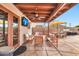 Inviting covered patio with ceiling fan, TV, comfortable seating, and outdoor dining area at 22412 N 20Th Pl, Phoenix, AZ 85024