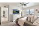 Bright main bedroom features a ceiling fan, large window, and a dresser with a TV at 22412 N 20Th Pl, Phoenix, AZ 85024