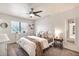 Bright main bedroom features neutral decor, a ceiling fan, and large window with natural light at 22412 N 20Th Pl, Phoenix, AZ 85024