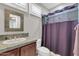 Bathroom features tiled countertop, vanity, and purple shower curtain at 2404 W Muirfield Dr, Anthem, AZ 85086