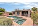 Backyard features a pool, spa, covered patio with dining set, and desert landscaping at 2404 W Muirfield Dr, Anthem, AZ 85086