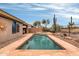 Backyard features a large pool, spa, desert landscaping, and a privacy fence at 2404 W Muirfield Dr, Anthem, AZ 85086