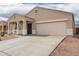 Inviting home front with a spacious driveway, two-car garage, and a covered porch area with a seating bench at 28916 N Selenite Ln, San Tan Valley, AZ 85143