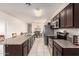 Open kitchen with stainless steel appliances, a large island with granite countertops, and view to dining area at 28916 N Selenite Ln, San Tan Valley, AZ 85143