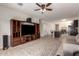 Cozy living room area with a large entertainment center, ceiling fan, and open access to the kitchen and dining area at 28916 N Selenite Ln, San Tan Valley, AZ 85143