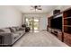 Comfortable living room featuring a ceiling fan, a large entertainment center, and sliding doors leading to the patio at 28916 N Selenite Ln, San Tan Valley, AZ 85143