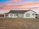 Backyard view of the neutral home with a covered patio and large sliding glass doors at 35597 W Jones Ave, Tonopah, AZ 85354