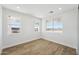 Bright bedroom with wood-look tile flooring and multiple windows offering exterior views at 35597 W Jones Ave, Tonopah, AZ 85354