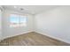 This bedroom features wood-look tile flooring and bright, natural light from a large window at 35597 W Jones Ave, Tonopah, AZ 85354